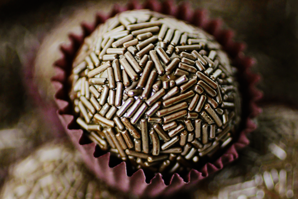 Close em brigadeiro amargo do Casal Garcia, com outros brigadeiros iguais no fundo desfocado.